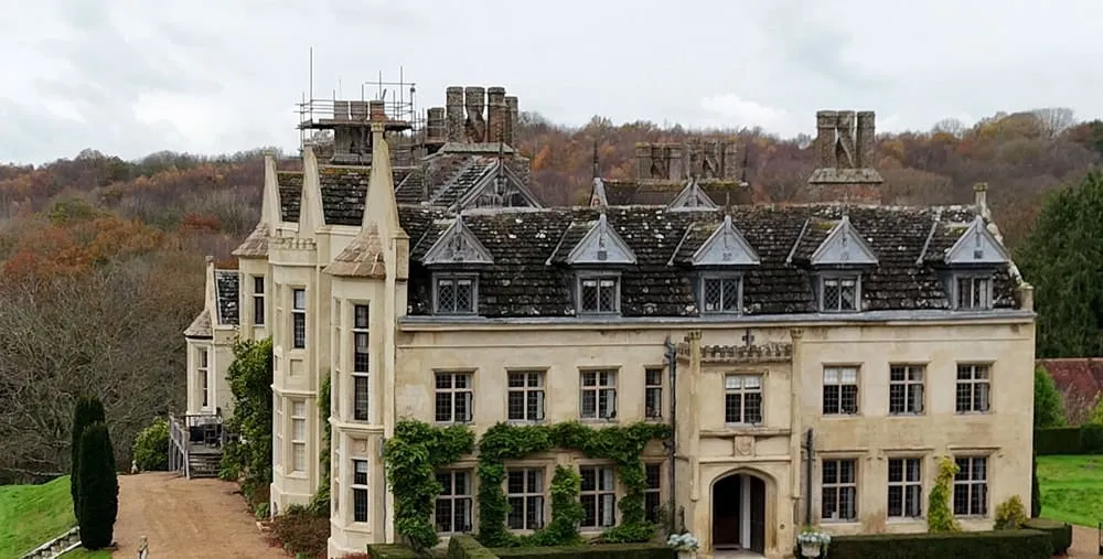 Cuckfield Park House, an Elizabethan stone house with dormers and ivy